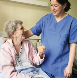 Pflegekraft hilft beim Ankleiden